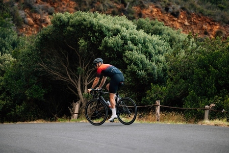 Back view of male cyclist riding a bicycle in wild terrain