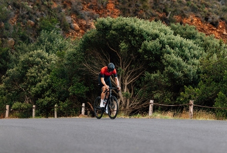 Young man riding a bicycle in wild terrain  Road bike rider practicing outdoors