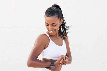 Happy female looking at her bicep  Young fit woman showing her muscles on the arm