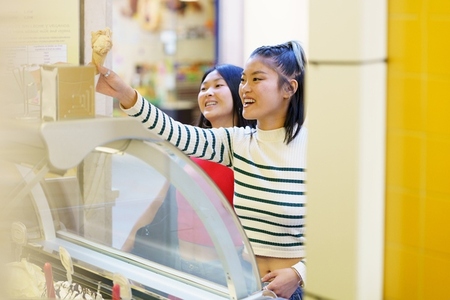 Happy Asian woman buying ice cream