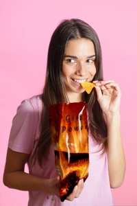 Woman eating spicy chips in studio