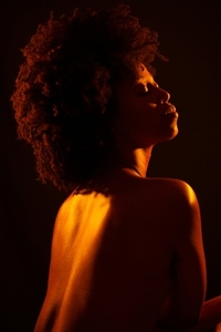 Nude African American woman under orange light