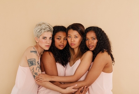 Four different women embracing each other  Young females posing together