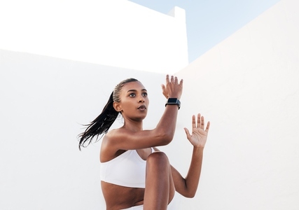 Slim female doing intense core exercises in a white outdoor studio