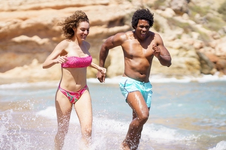 Happy diverse couple having fun in sea water
