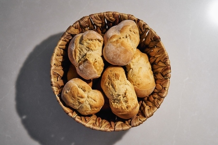 Still life view from above rustic bread rolls in brown basket
