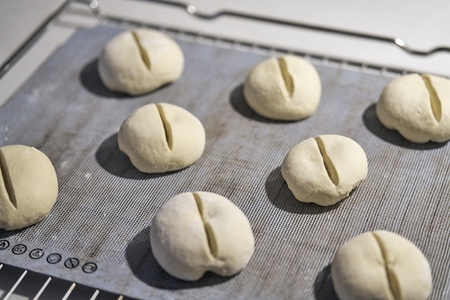 Cut bread roll dough on cookie sheet
