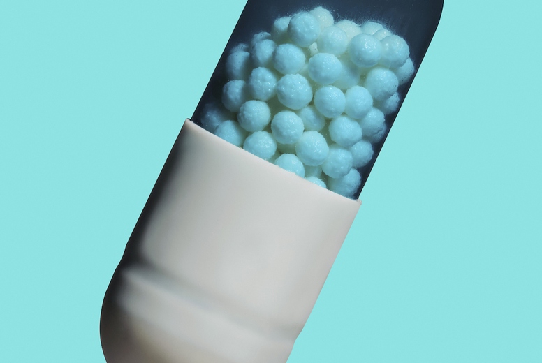 Close up granules inside medicine capsule on blue background