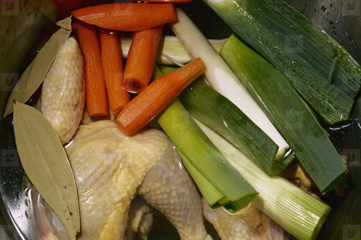 Close up vegetables and chicken cooking in pot