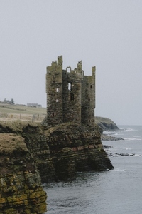 Castle ruins on cliff above ocean coastline Keiss