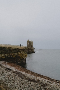 Castle ruins on cliff above ocean coastline Keiss