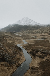 Winding river below snowcapped mountain in remote landscape 02