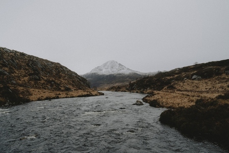 Winding river below snowcapped mountain in remote landscape 03