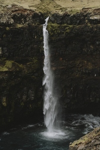 Tall waterfall over mossy cliff