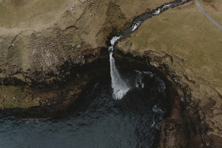 Aerial view waterfall flowing over cliff into sea 02