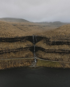 Three tier waterfall flowing over cliff into sea