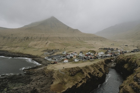 Remote village below foggy hill