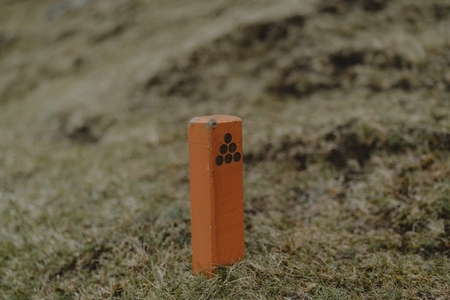 Close up orange hiking sign in grass