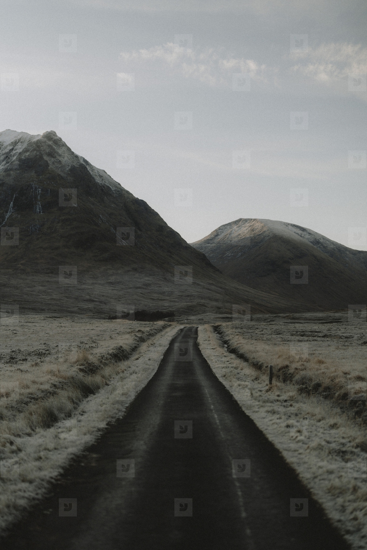 Icy road below tranquil remote mountains