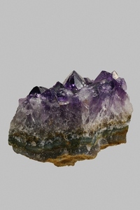 Close up textured purple Uruguayan amethyst crystal on gray background