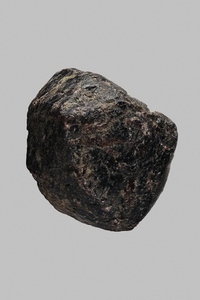 Close up black Indian almandine stone on gray background