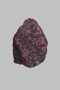 Close up textured purple Tanzanian ruby and zoisite stone on gray background