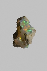 Close up iridescent multicolored welo opal stone on gray background