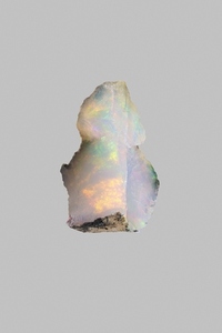 Close up iridescent multicolored welo opal on gray background 03