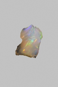 Close up iridescent multicolored welo opal stone on gray background 02