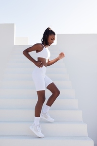 Side view of a slim woman running down on stairs outdoors  Full length of young fitness female practicing outdoors