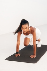 Woman doing core exercises on a mat and looking at camera