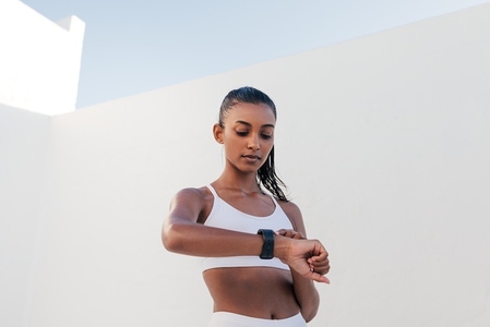 Slim female checking pulse on a smartwatch  Fitness influencer checking heart rate