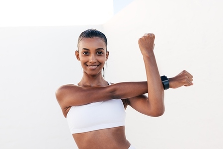 Smiling woman flexing her hands before exercises  Young slim female warming up her hands and looking at the camera