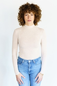 Curly haired woman standing against white background