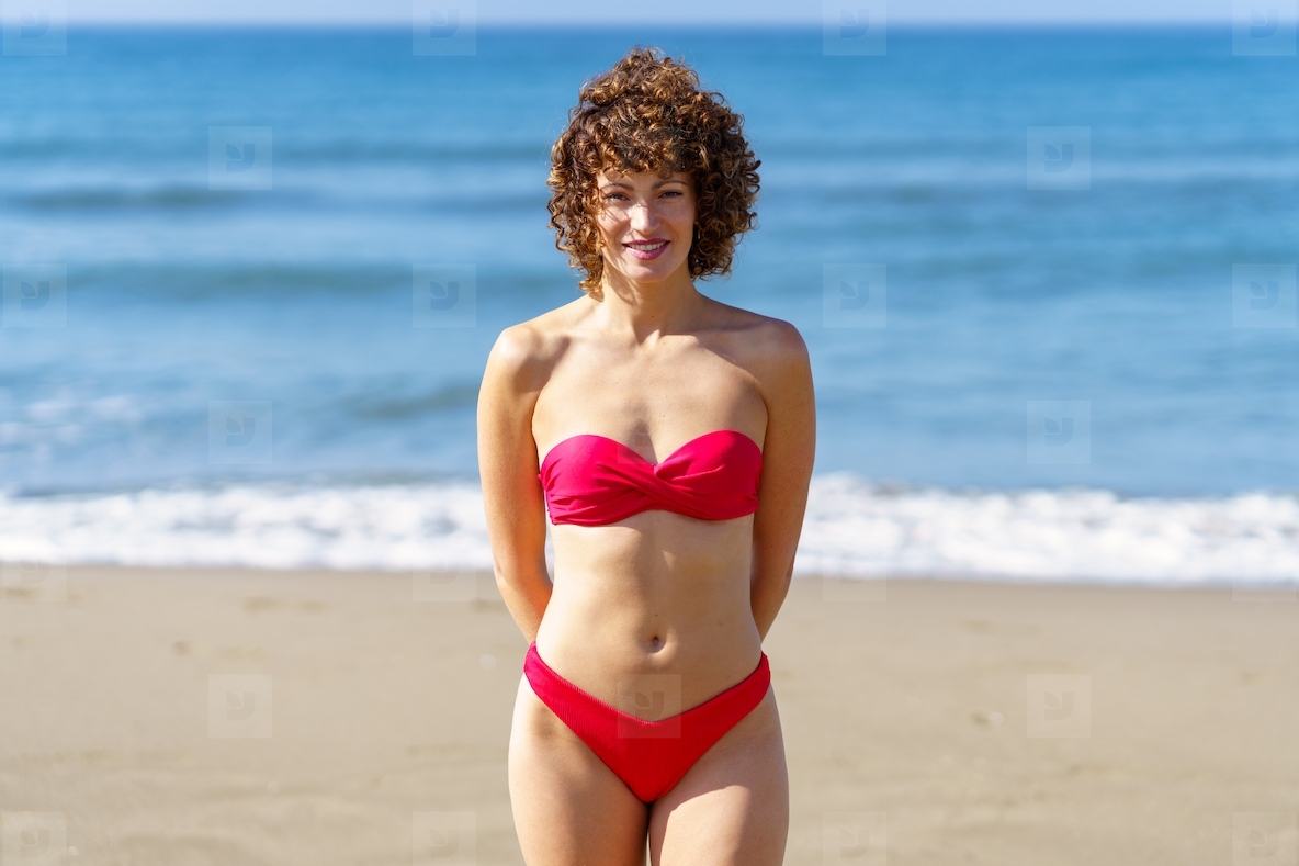 Smiling woman in red bikini on beach
