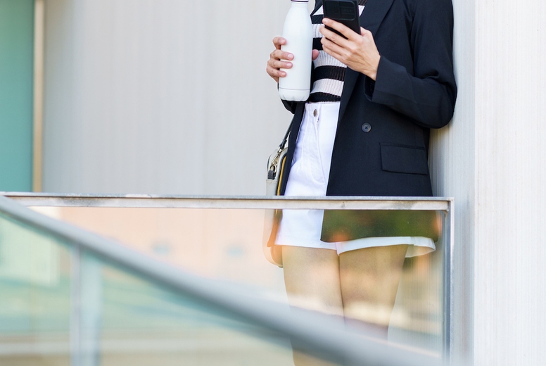 Adult woman using mobile phone while looking away