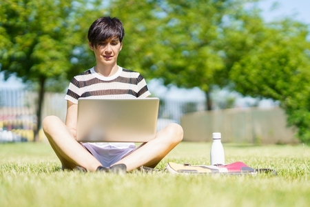 Woman working on laptop in park
