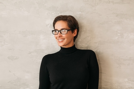 Portrait of a middle aged businesswoman in eyeglasses smiling and looking away