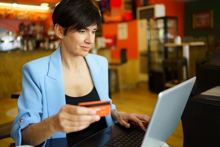 Adult woman using debit card for online payment