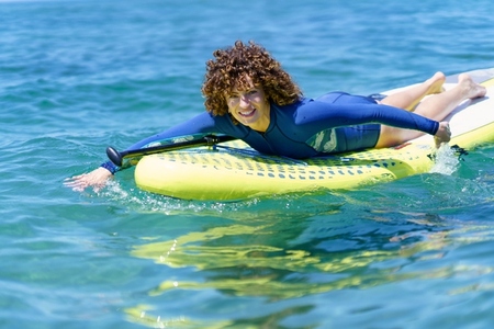 Smiling lady on SUP board in water