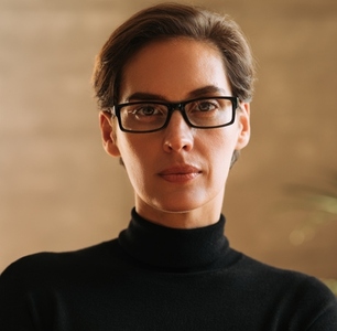 Close up portrait of a confident businesswoman with short hair wearing eyeglasses looking straight into a camera