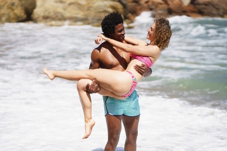 Happy diverse couple enjoying time together on beach