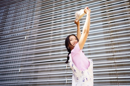 Carefree Asian woman against metal wall
