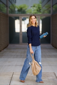 Cheerful female walking outside apartment building