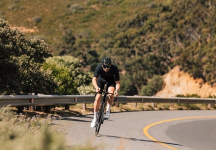 Professional cyclist riding his road bike on a curvy mountain road