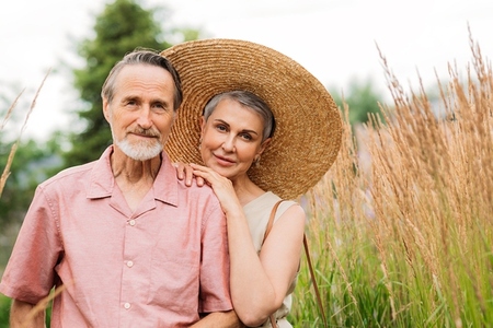 Portrait of an aged people standing together on the field  Mature husband and wife looking at the camera