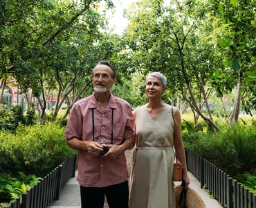 Aged husband and wife walking together in the park