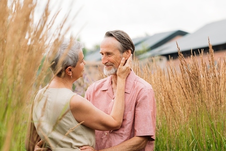 Aged romantic couple on a wheat field  Mature man and woman on a wheat field