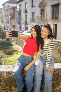 Cheerful Asian women taking selfie
