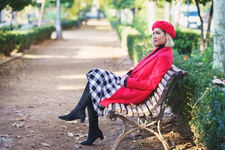 Stylish woman on bench in autumn park
